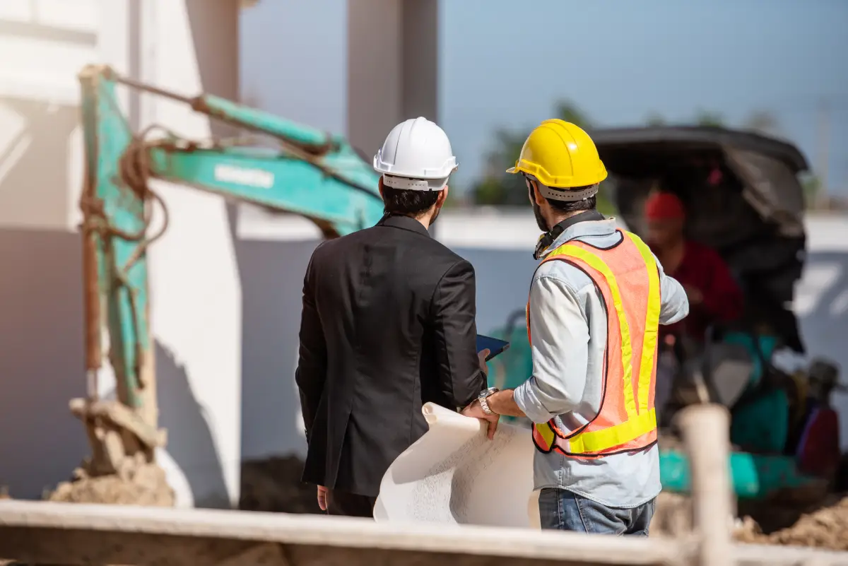 Two Froehlich Construction workers engraving structural components on a commercial construction site